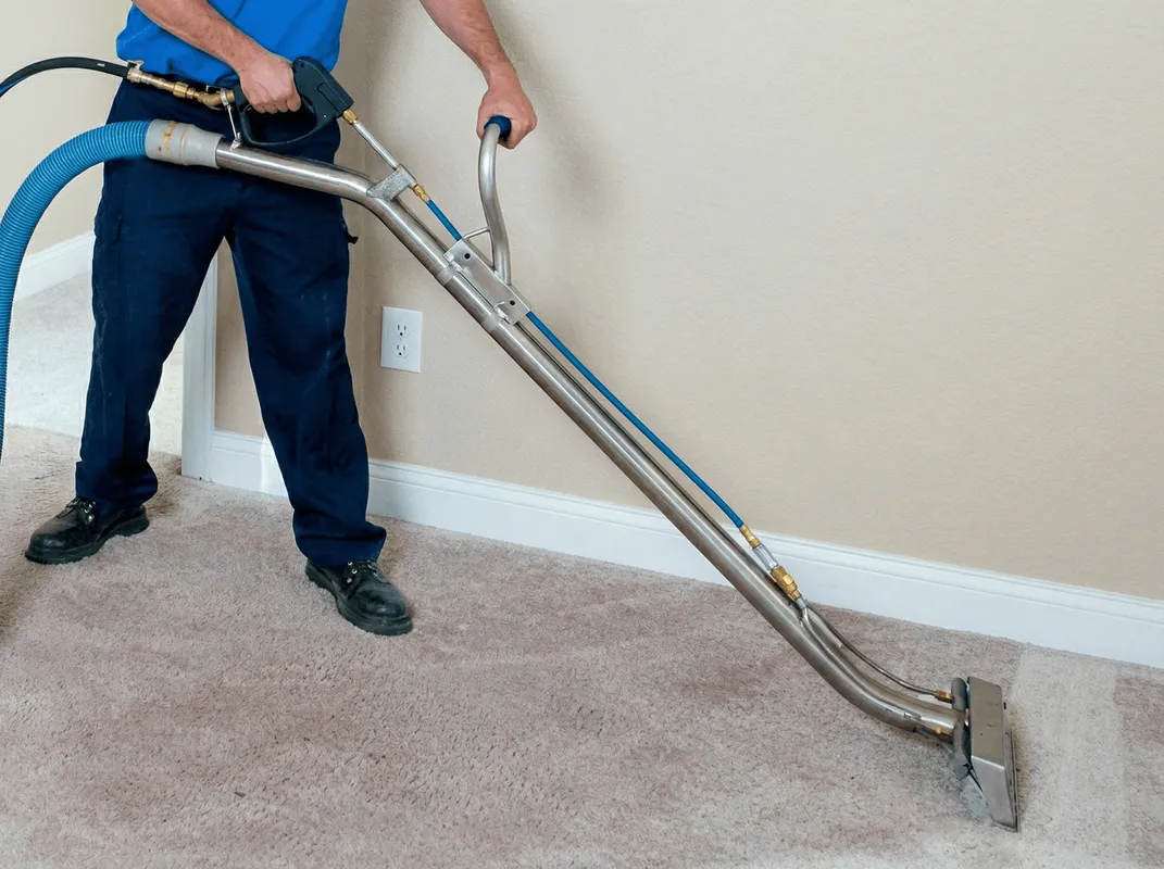 Professional operating a liquid removal machine on a carpeted floor in Seattle, WA
